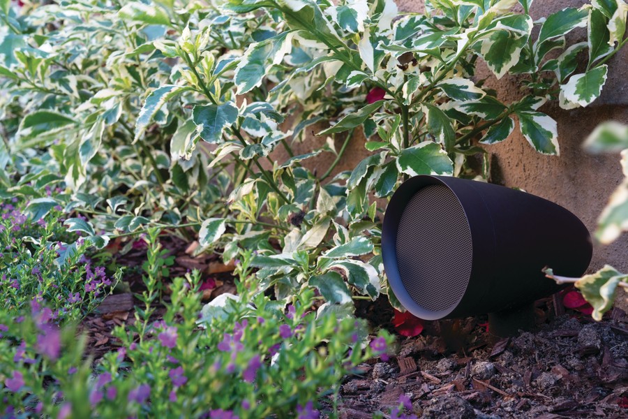 A speaker discreetly installed in a garden area as part of an outdoor sound system in a Houston home. 