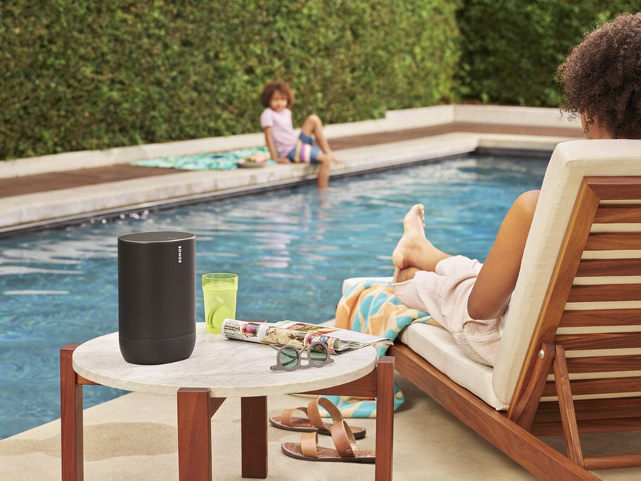 Relaxing poolside scene with a wireless speaker, woman lounging on a chair, and child playing in the pool.