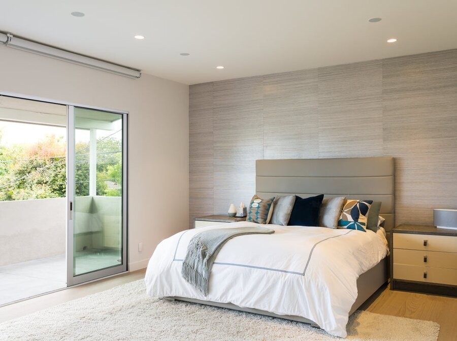 A bedroom featuring Lutron’s Ketra lighting fixtures and a balcony with a window.