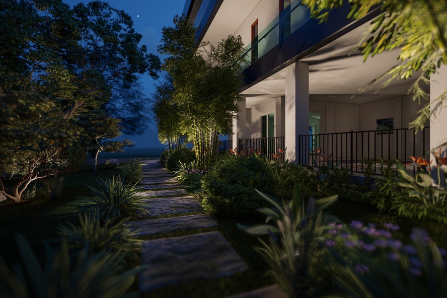 Coastal Source uplights highlighting trees along a walking path next to a two-story luxury home.